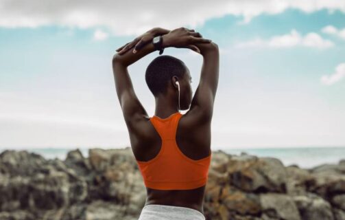 mulher com os braços levantados mostrando o resultado da hipertrofia muscular