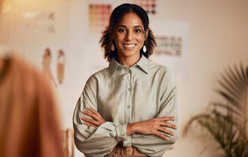 mulher sorrindo e de braços cruzados